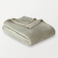 Folded green blanket on a light gray background