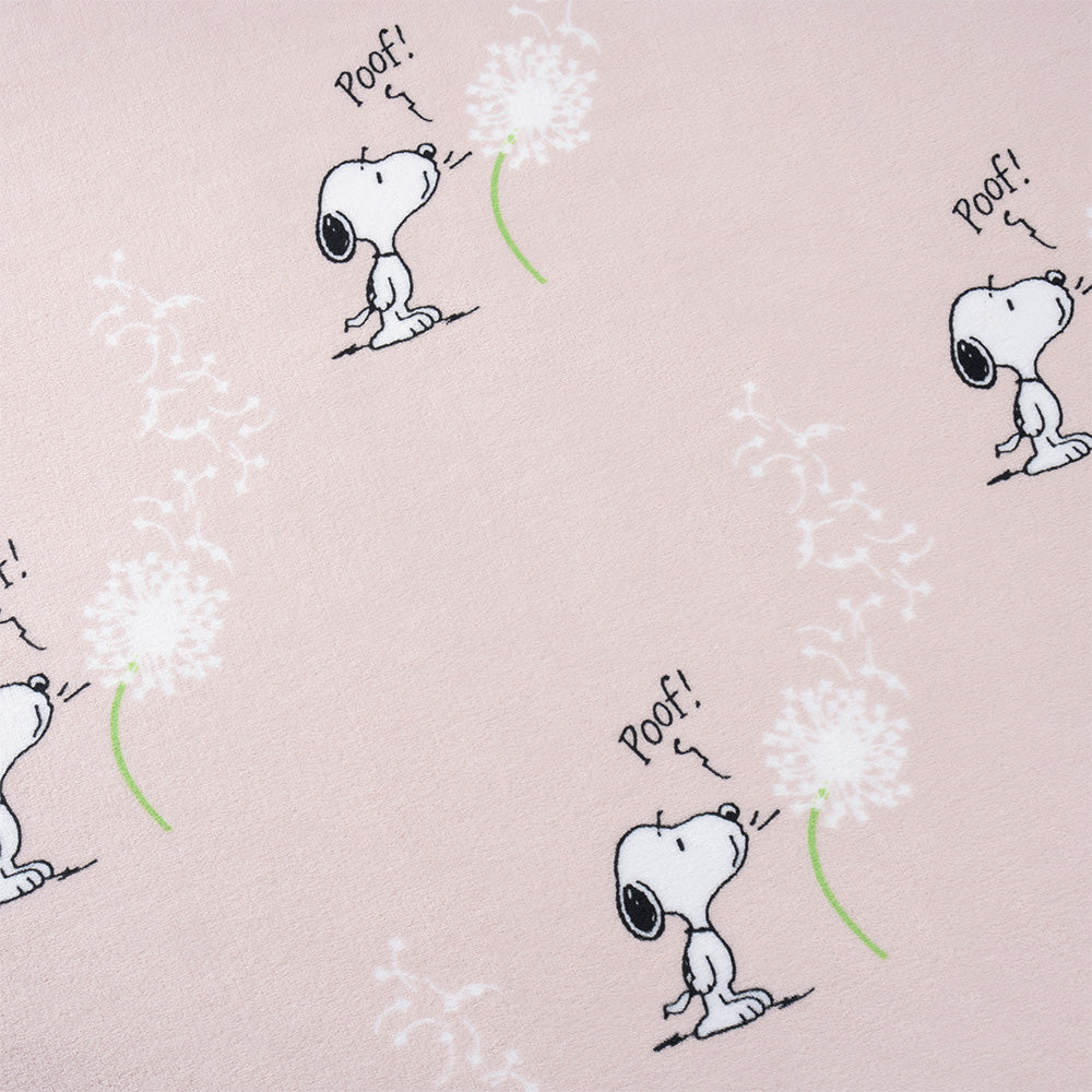 Close up of a pink Peanuts make a wish throw, displaying the print and silky smooth texture.