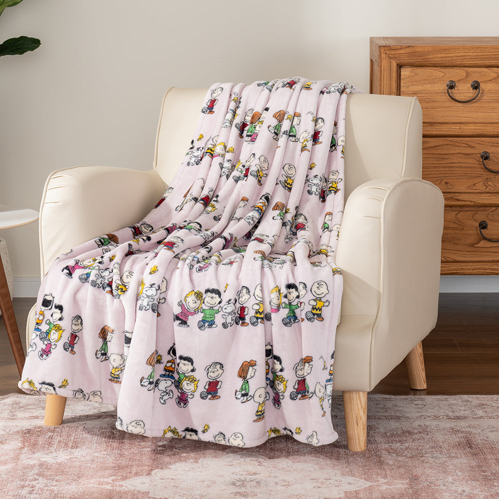 Lilac colored peanuts character throw draped enatly over a beige chair.