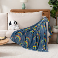 A blue throw blanket with Snoopy on a rainbow draped over an armchair.