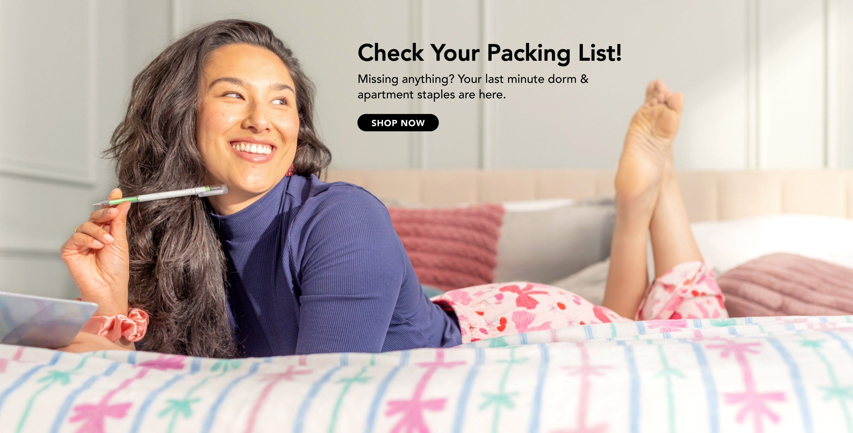 Title: Check Your Packing List!

Sub-Title: Missing anything? Your last minute dorm & apartment staples are here.

Image: Girl laying on bed with note book and gel pen, wearing bow patterned PJs on a bow patterned blanket.
