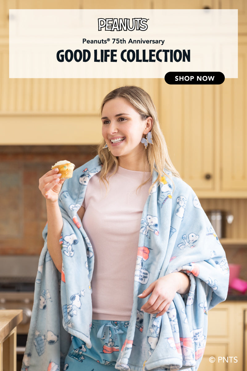 Peanuts® 75th anniversary the Good Life Collection. Photo of a girl in a kitchen baking sweets, featuring a print with goodies.