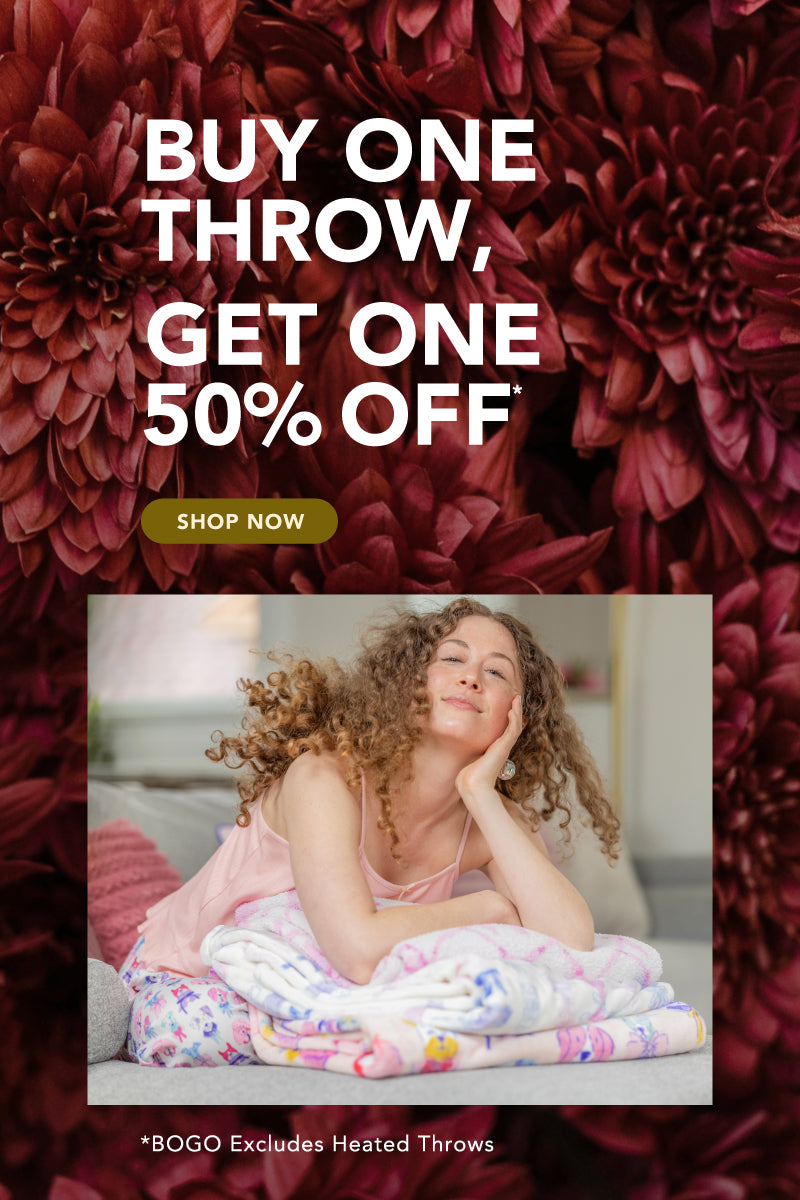 Buy One Throw, Get One 50% Off*
*BOGO excludes Heated Throws
Photo of model with a stack of colorful throws, red floral background