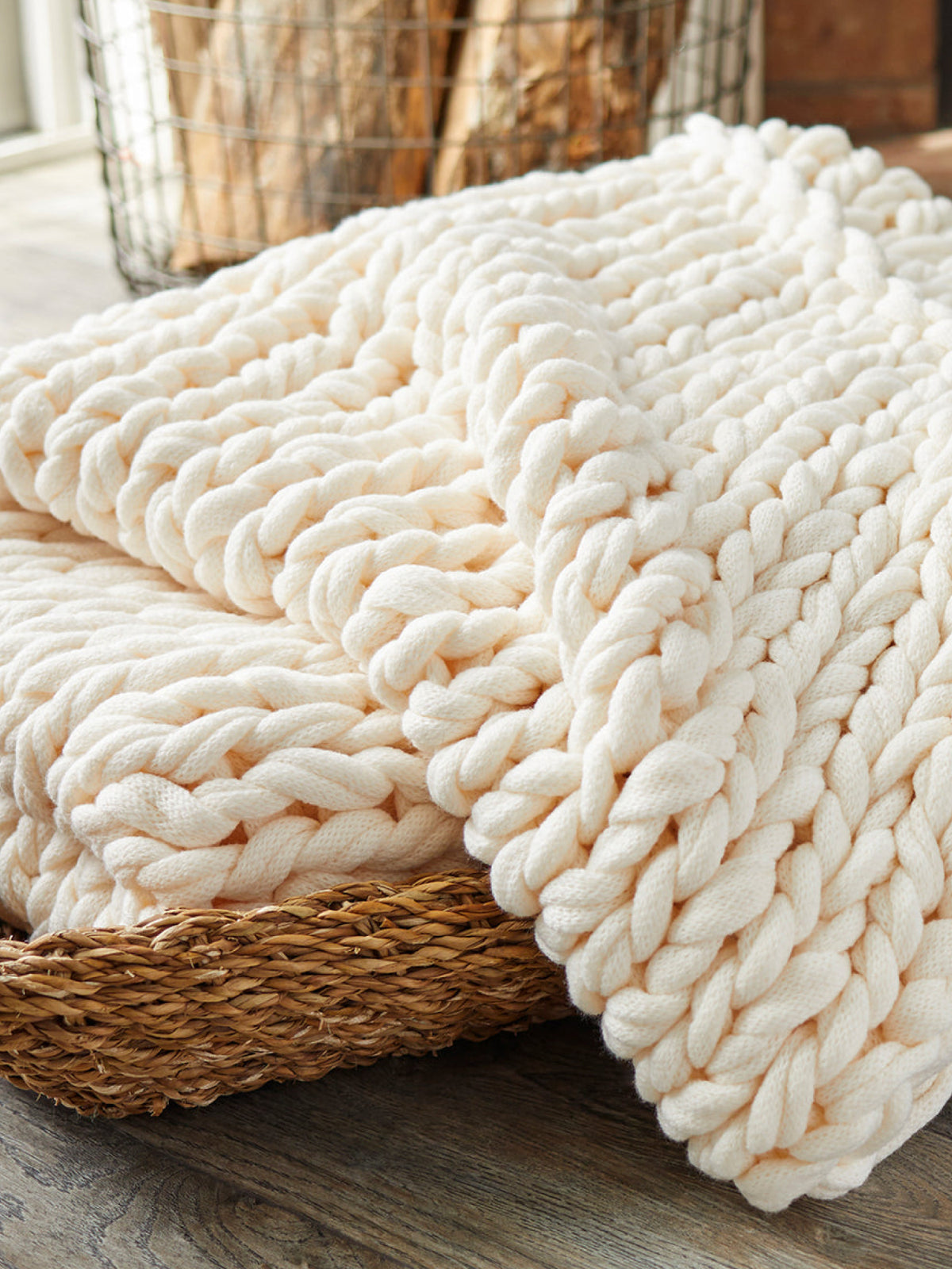Spring collection image featuring our Sailors Knot Throw in Natural folded in a woven basket.