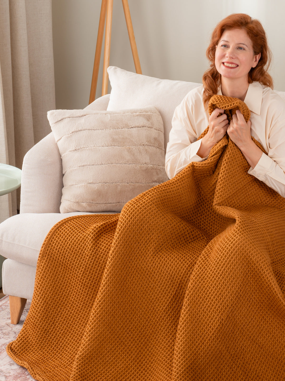Throws collection image featuring our Waffle Knit Throw in Butterscotch draped over a woman's legs.