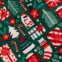 Christmas-themed fabric pattern with presents, candy canes, and stockings on a green background.
