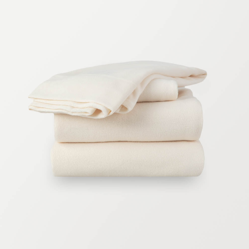 A stack of ivory sheets neatly folded on a white background.