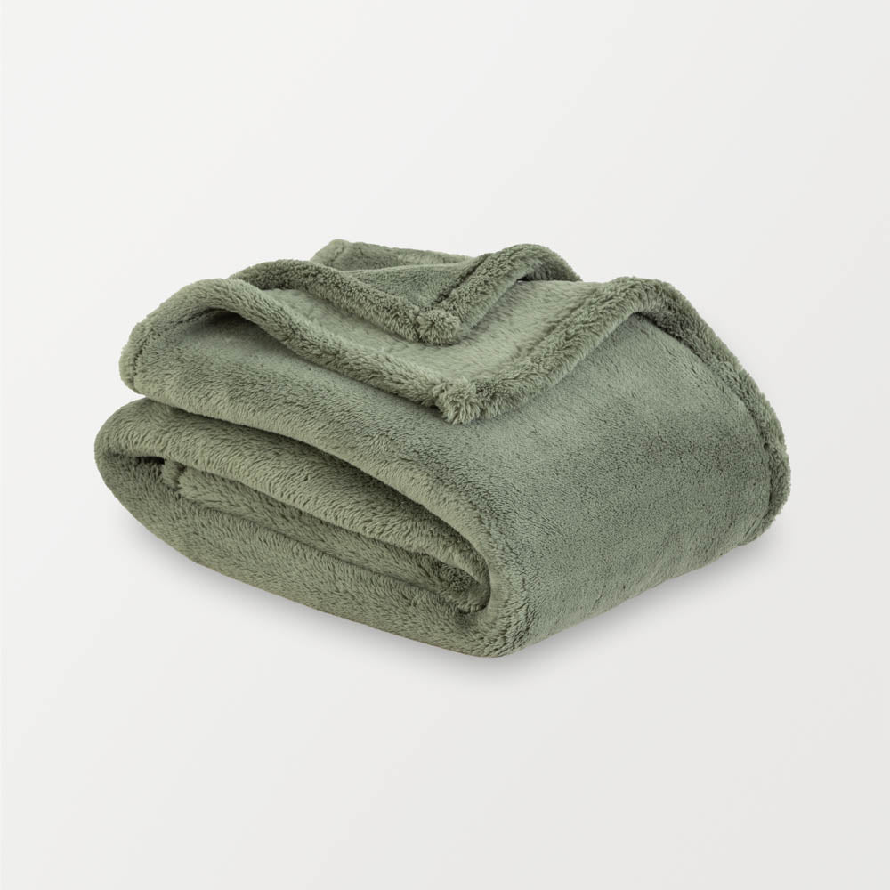 Green extra fluffy throw folded neatly on a white surface.