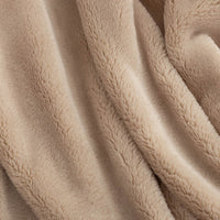 Close up of a tan extra-fluffy throw.