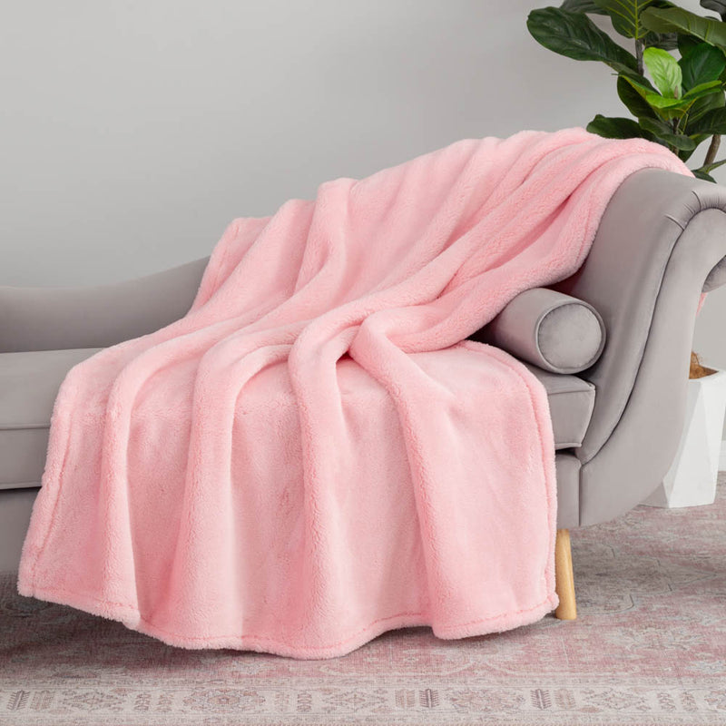Pink extra fluffy throw draped neatly over a grey chair.