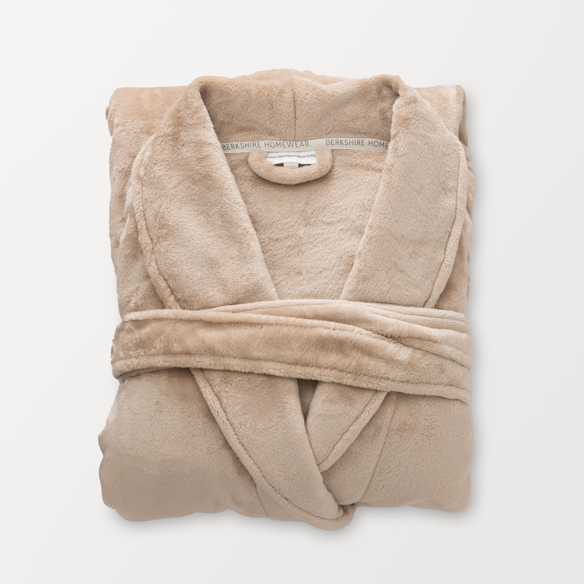 A tan VelvetLoft Luxury Plush Spa Robe folded neatly on a white surface.