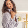Woman wearing a lilac robe in a bathroom setting