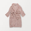 A pink VelvetLoft Luxury Plush Spa Robe laid flat on a white surface.