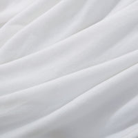 A close up of a white velvety plush throw displaying its silky smooth texture.