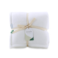 Packaged picture of a white velvety plush throw secured neatly with a bow and a hang tag.