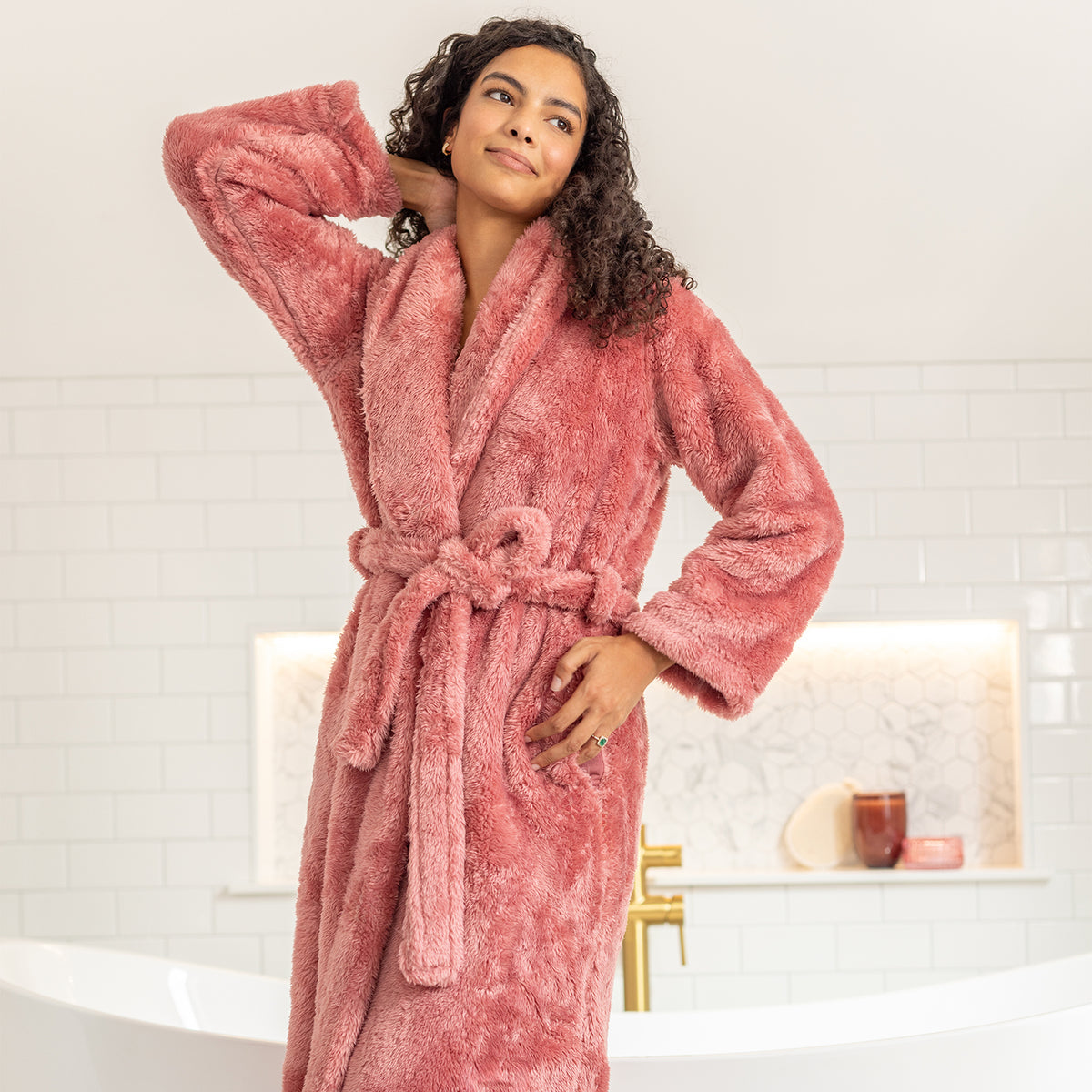 Woman wearing a pink robe in a bathroom setting