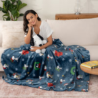 Woman sitting on a couch with a Snoopy-themed blanket and plush toy