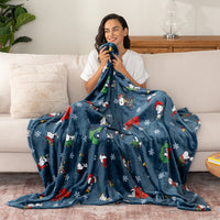 Woman holding a blue blanket with festive designs on a couch