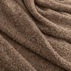 Close up of the fabric on a brown throw.
