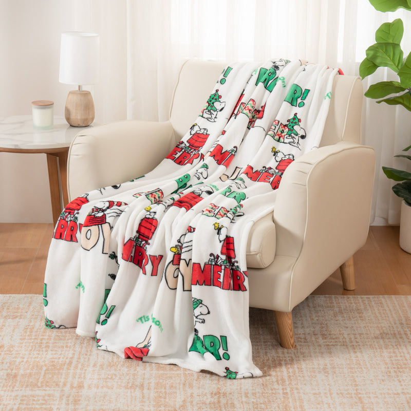 Decorative blanket with festive design draped over a chair in a living room.