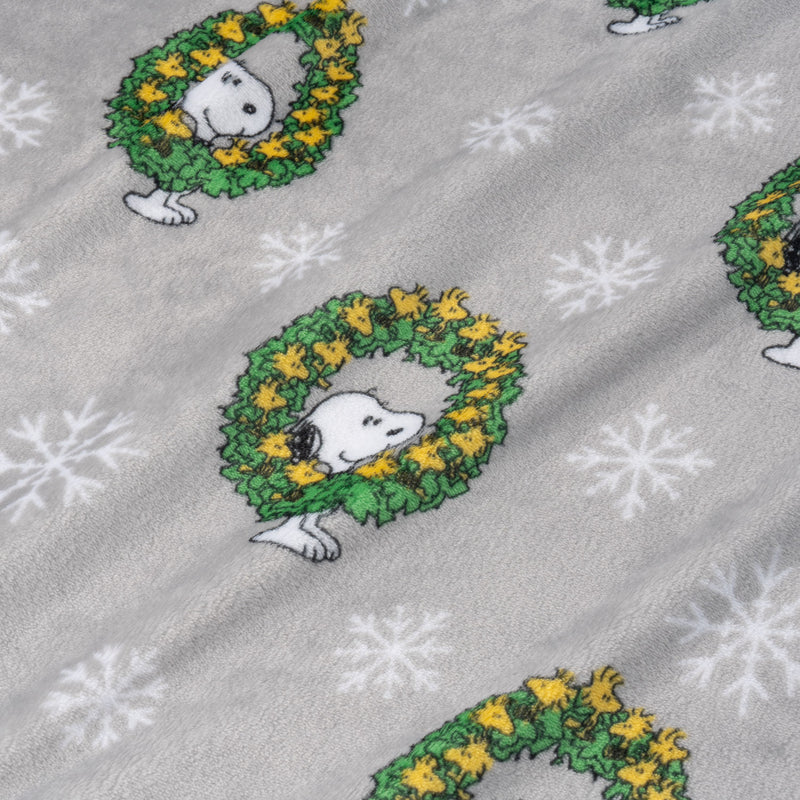 Fabric with Snoopy in wreaths and snowflakes on a gray background