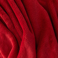 A close-up of the deep, velvety texture of a red PrimaLush Cape Wrap.