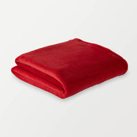 A folded bright red PrimaLush Cape Wrap displayed on a white surface.