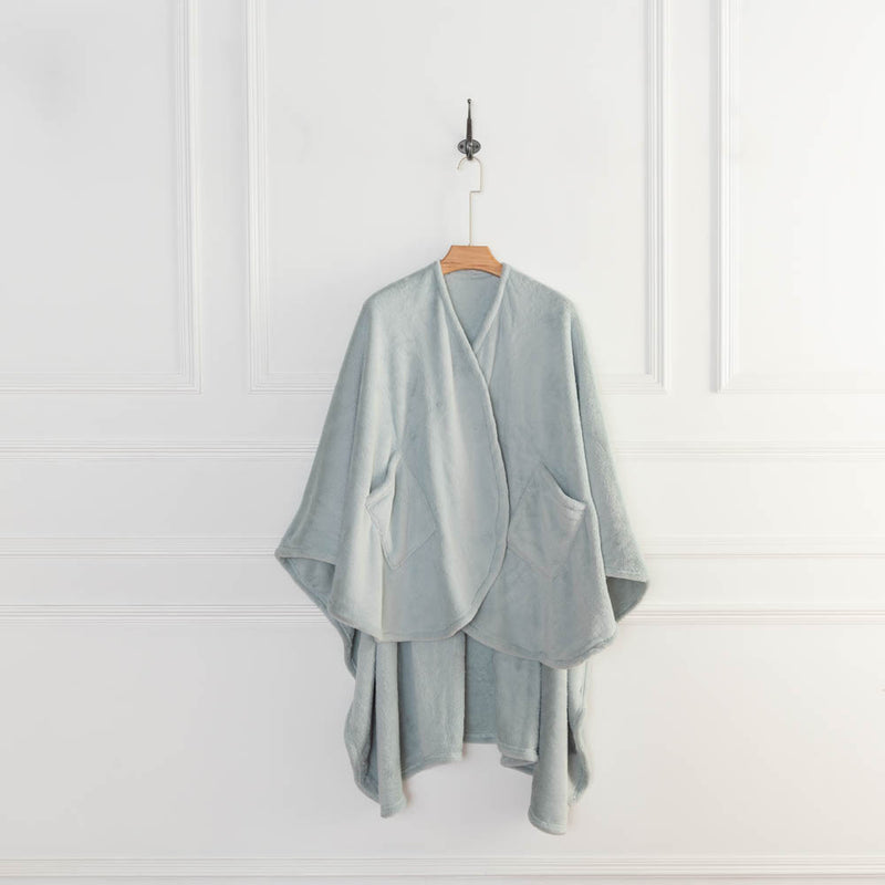 A light blue PrimaLush Cape Wrap hanging neatly on a wall hook against a white background.