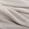 A close-up of the soft, fuzzy texture of a cream PrimaLush Cape Wrap.