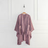 A purple PrimaLush Cape Wrap displayed on a hanger in a bright space.