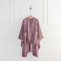 A purple PrimaLush Cape Wrap displayed on a hanger in a bright space.