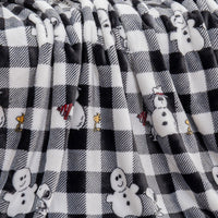 Close up of a black and white snowman checkered peanuts throw displaying its smooth and plush texture.