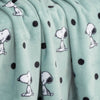 Close up of a blue polka dot snoopy throw displaying its smooth plush texture.