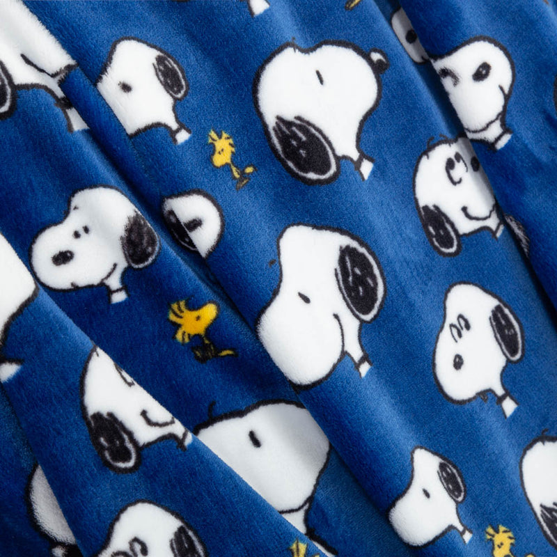 Close up of a cobalt blue printed Peanuts throw, displaying the silky smooth plush texture.