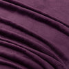 A close-up of a plum velvet blanket showing its smooth texture.