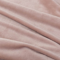 A close-up of a light pink velvet blanket highlighting its soft texture.