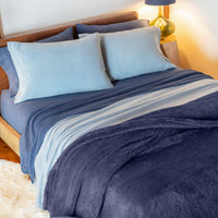 Blue bedding dressed on a bed.