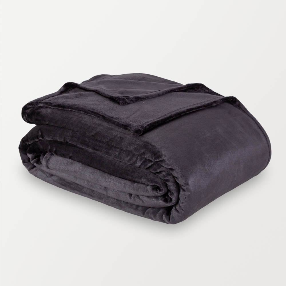 Black velvety plush family blanket folded neatly on a white surface.