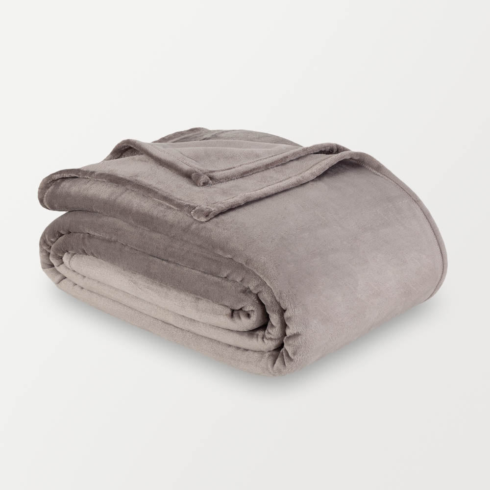 Grey velvety plush family blanket folded neatly on a white surface.