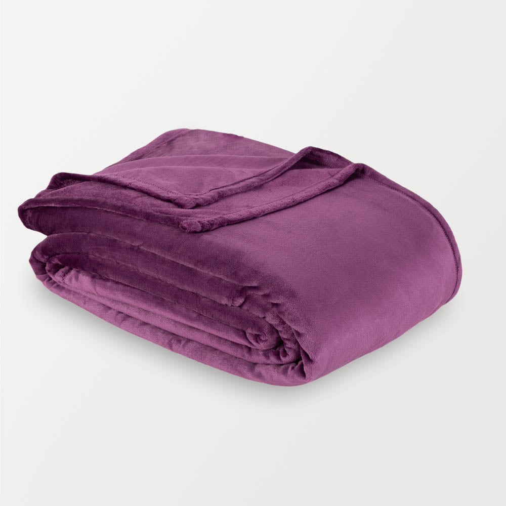 A purple velvety plush family blanket folded neatly on a white surface.