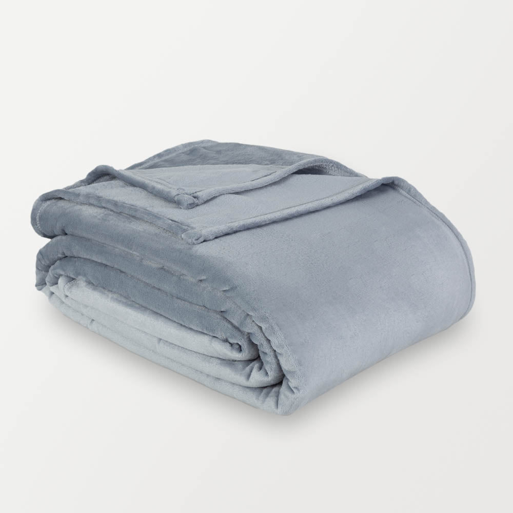 Blue velvety plush family blanket folded neatly on a white surface.