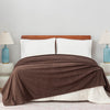 Polartec Softec Microfleece Blanketin brown, neatly spread over a white bed with blue lamps on each side.