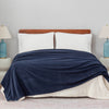 Bedroom setup with a Polartec Softec Microfleece blanket in navy blue spread over the bed.