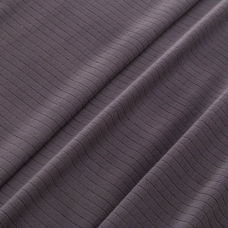 Close-up of the microfleece material of the blanket in dark gray, highlighting its soft texture.