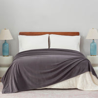 Polartec Softec Microfleece blanket in gray, spread elegantly over a bed in a cozy bedroom setup.