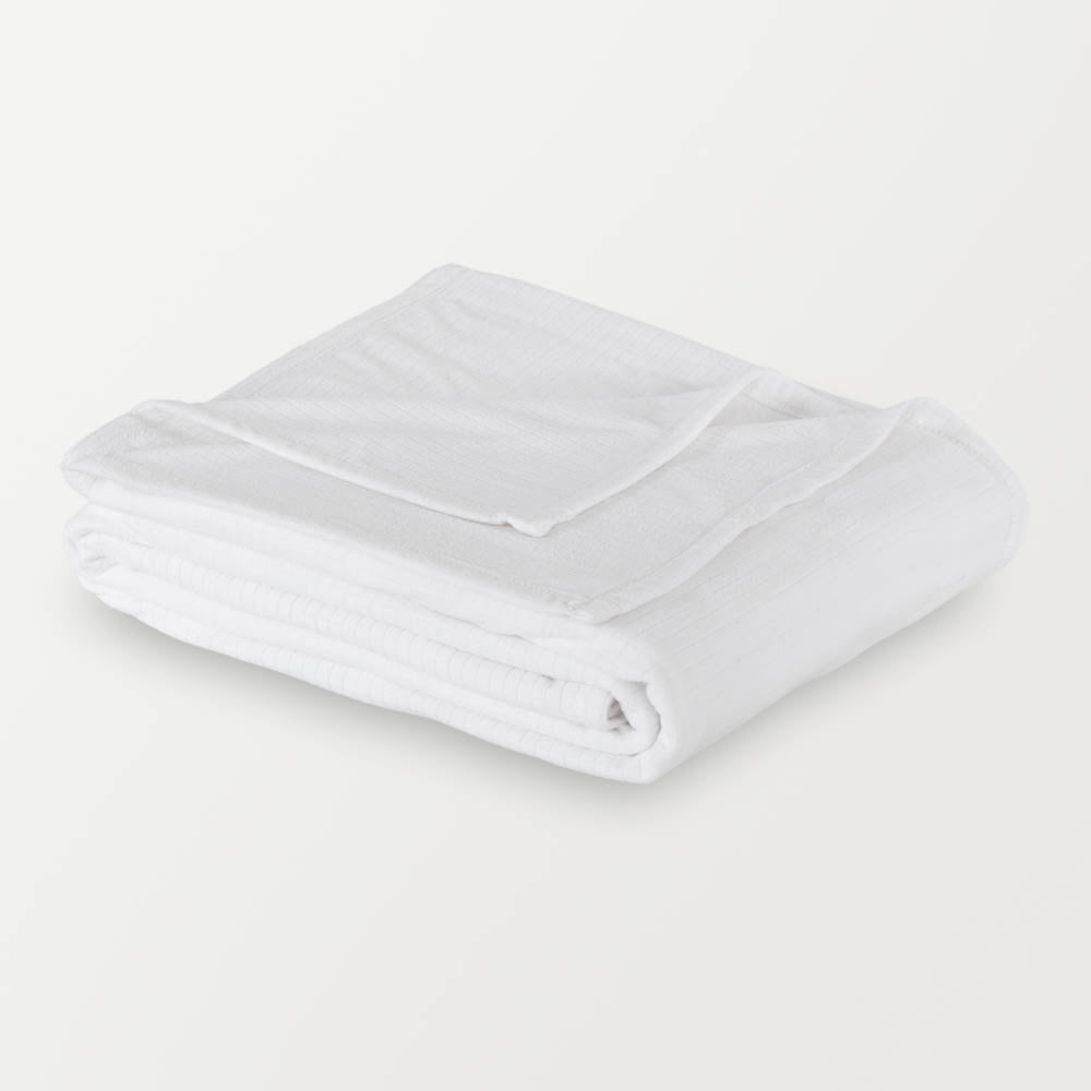 Folded white Polartec blanket on a white background, highlighting its soft texture and design.