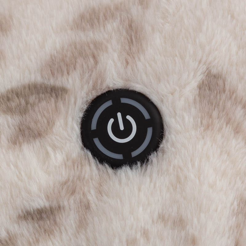 A close-up of a white heated throw with a power button and fluffy texture.