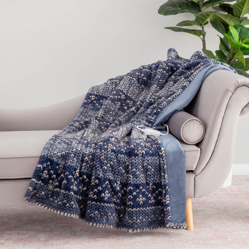 A dark blue patterned heated throw draped over a grey chair, with a power button visible.