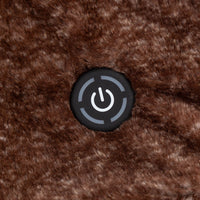 A close-up of a chocolate brown heated throw with a power button on its surface.