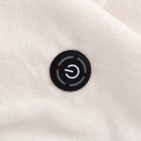 Close up of the power button on a cream heated wearable throw.